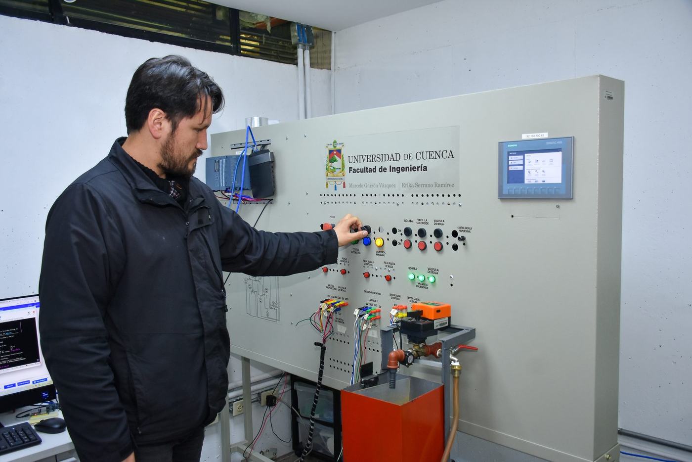 Investigador opera el tablero de control de la planta de multitanques